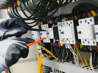 Electrician testing terminals in an electrical panel